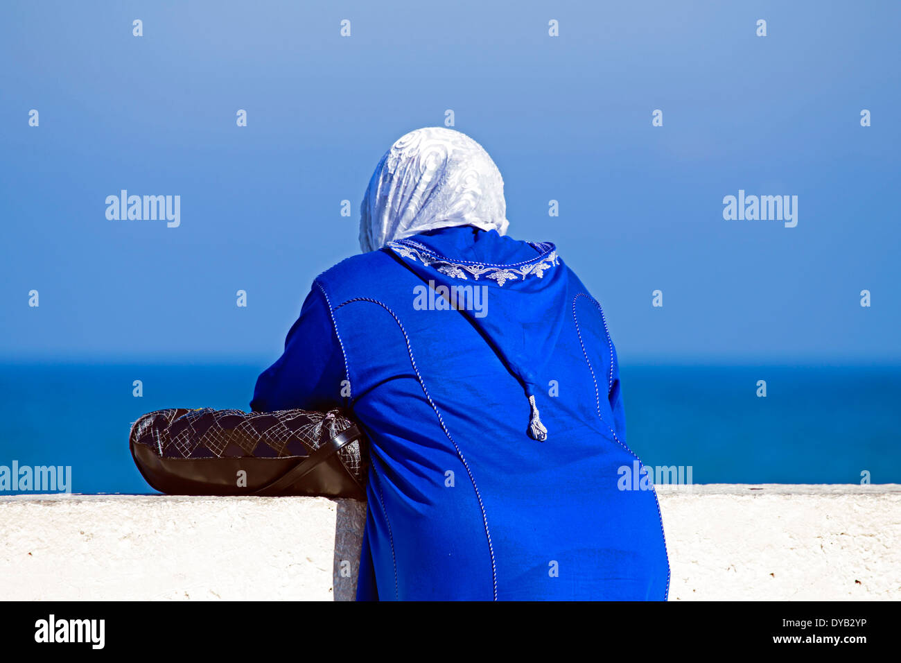Arabische Frau mit islamischen Kopftuchs mit Blick auf den Ozean Stockfoto