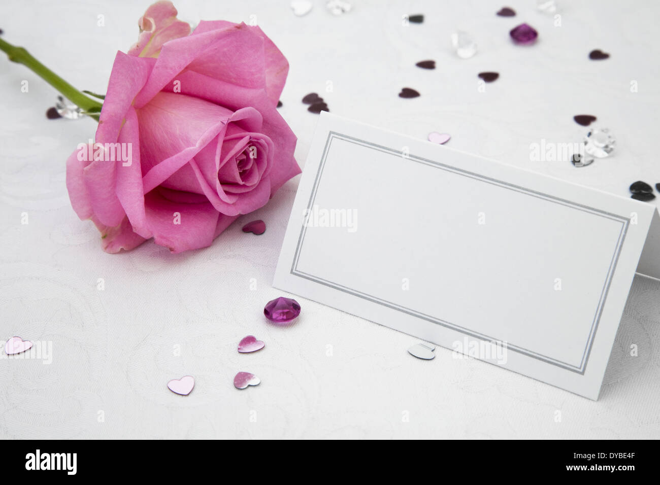 Rosa Rose und leere Tischkarte mit Tischdekoration Hochzeit Stockfoto