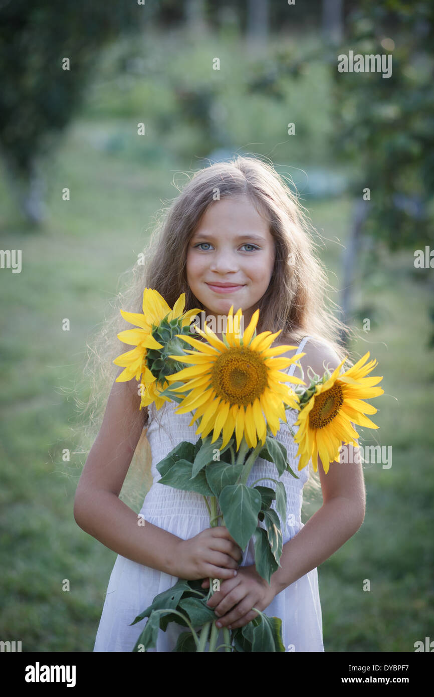 Mädchen mit Sonnenblumen im Garten Stockfoto