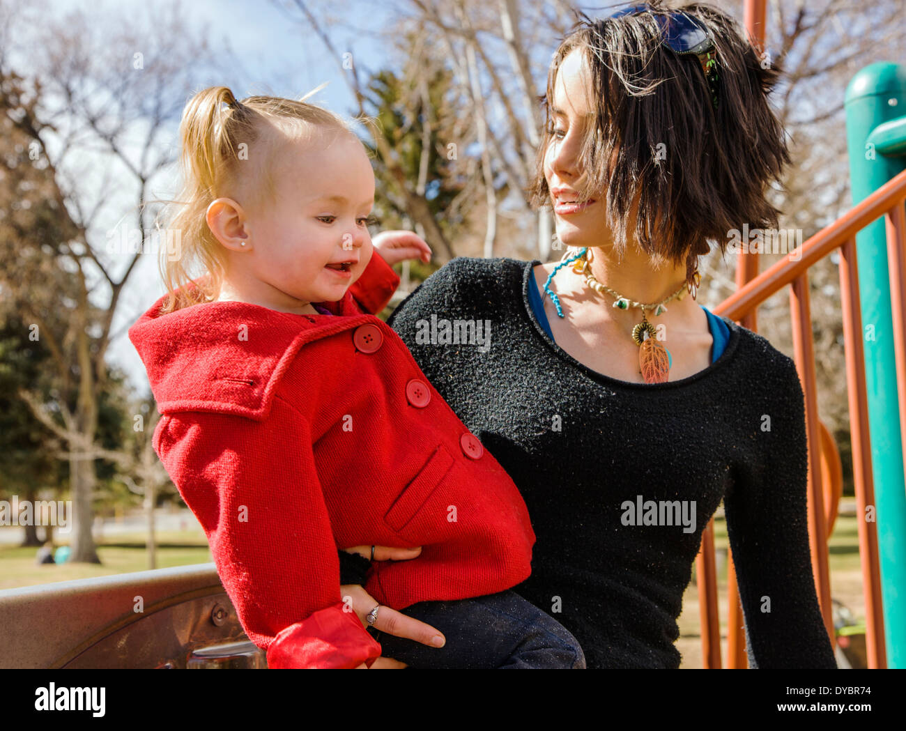 Schöne junge Mutter auf Park Spielplatz mit liebenswert, niedlich 16 Monate Baby Girl Spielen Stockfoto