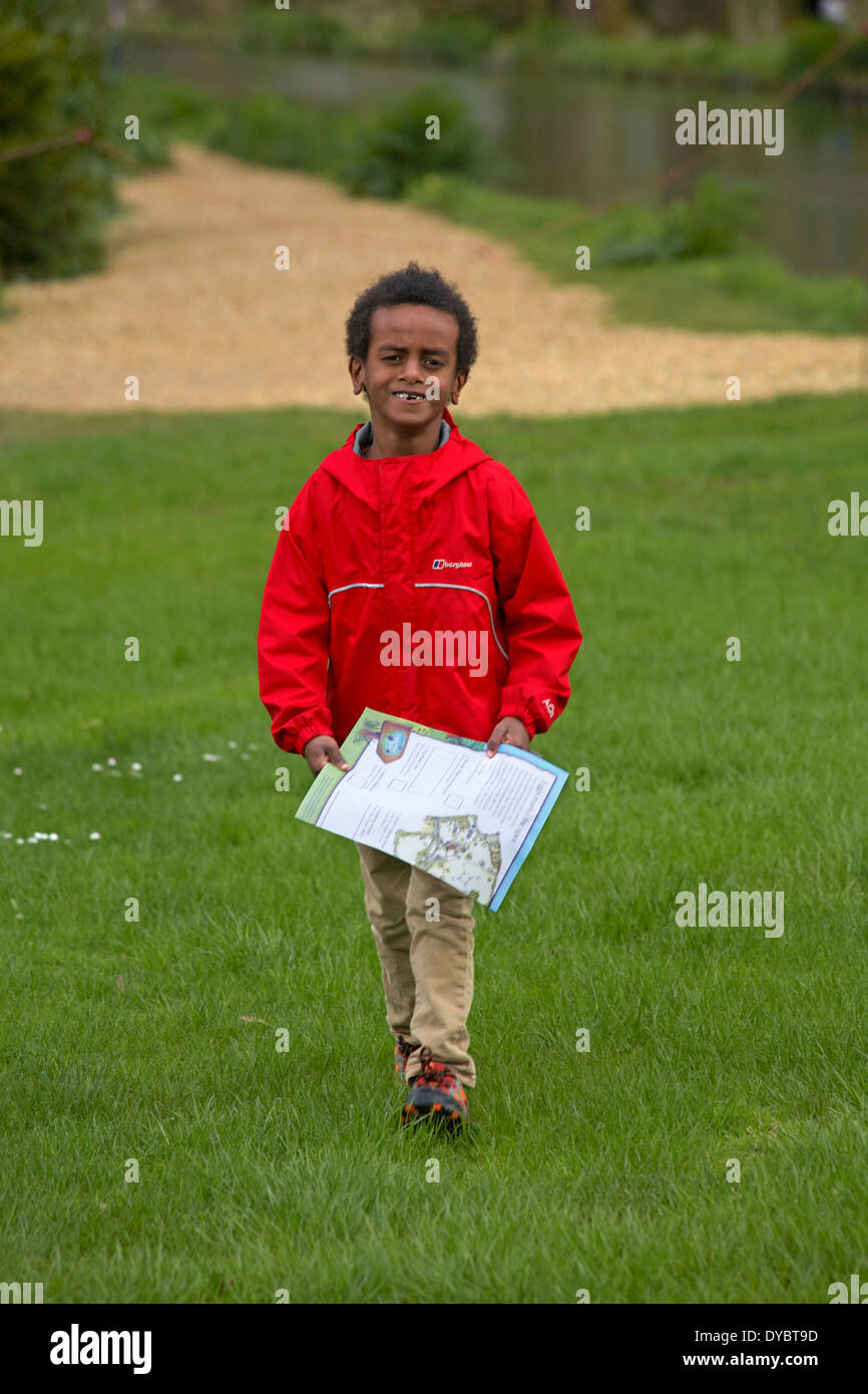 lächelnde junge mit fehlenden Frontzähne Wandern und Durchführung Easter Egg Hunt Karte Stockfoto