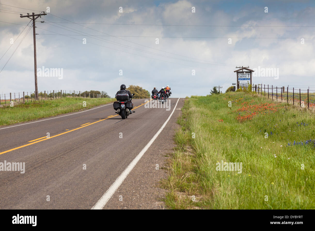 Motorradfahrer genießen Texas Bluebonnets und Indian Paintbrush entlang State Highway 362 Bereichen in der Nähe von Whitehall, Texas. Stockfoto