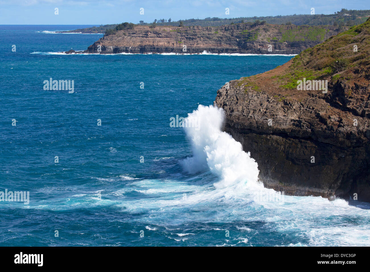 Mächtige Wellen im Pazifischen Ozean stürzen am Nordufer von Kauai ab. In den Klippen sind Schichten vulkanischer Lava und Tufffelsen zu sehen. Stockfoto