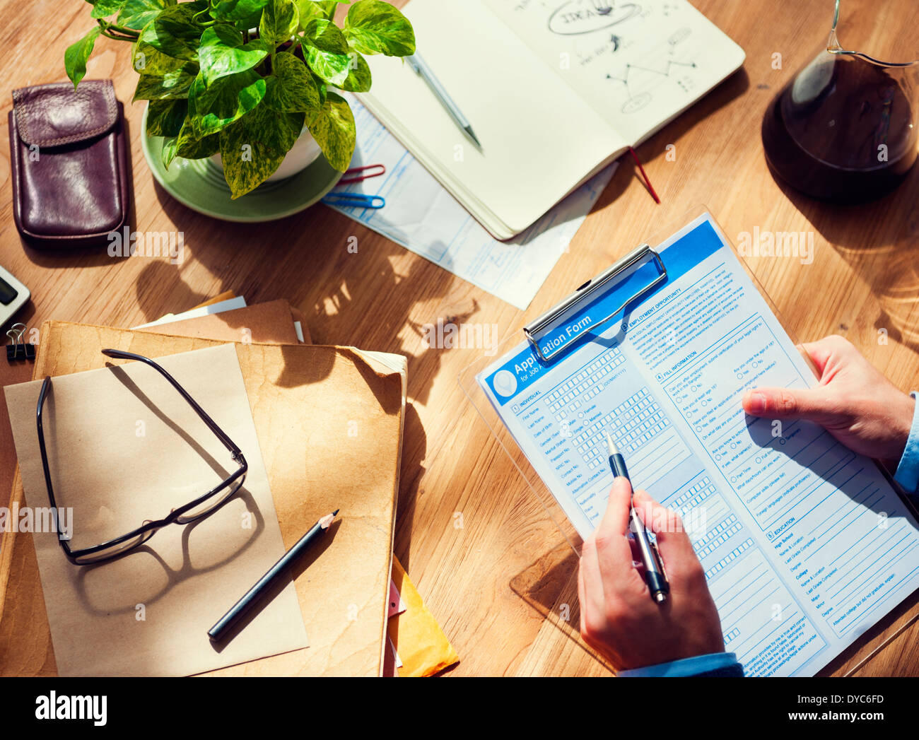 Geschäftsmann, Ausfüllen eines Formulars auf Holztisch Stockfoto