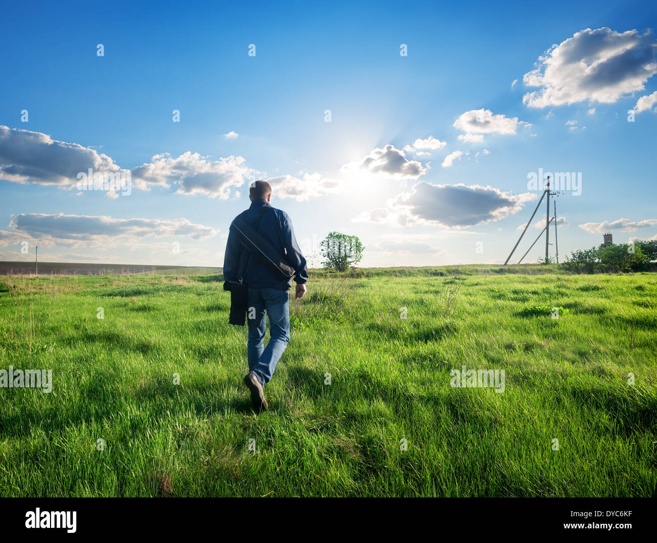 Mann zu Fuß auf die grüne Feder-Feld Stockfoto