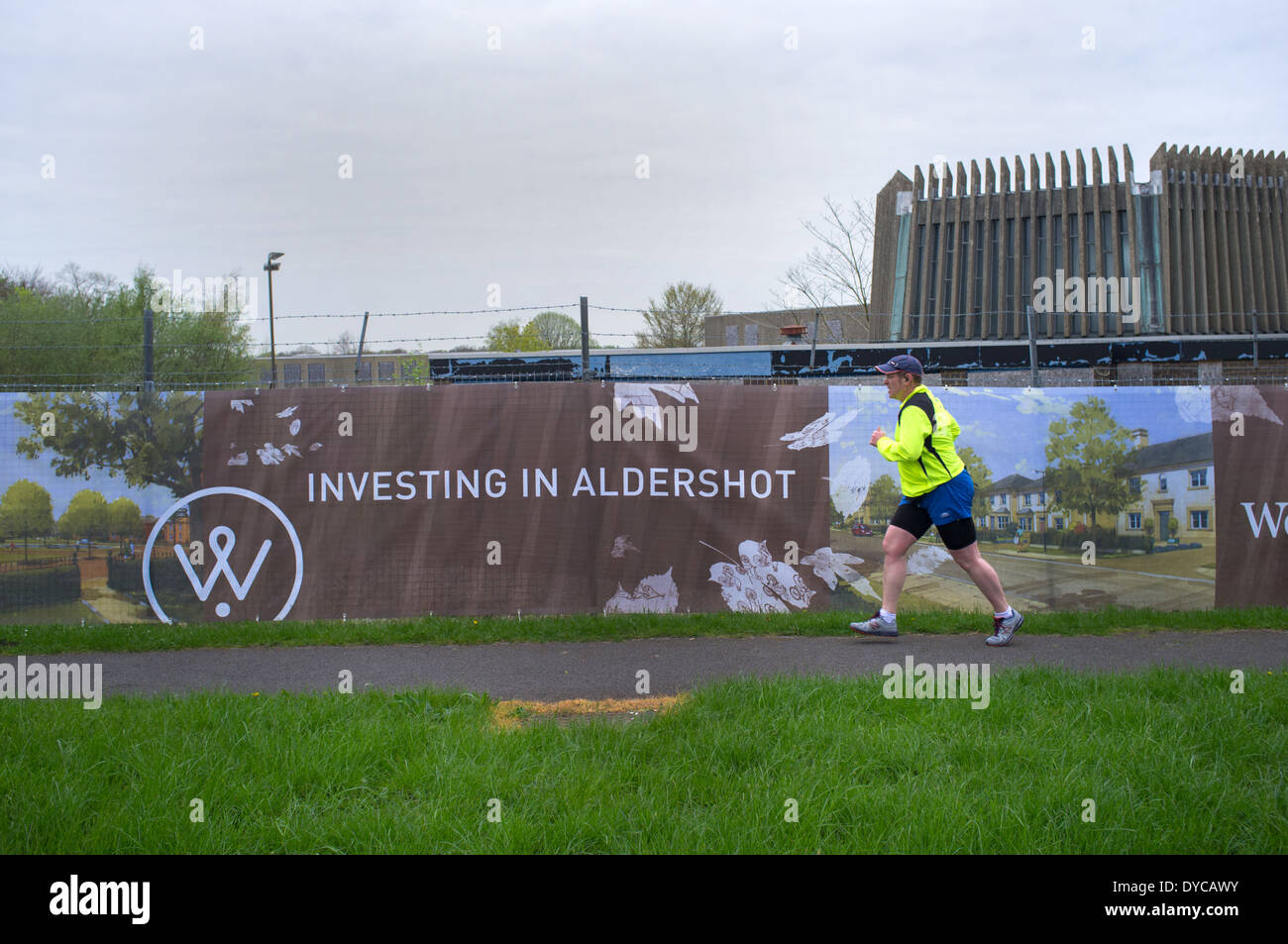 Ein Mann läuft vorbei an einer einsamen Armee Website in Aldershot, England. Das Land ist für Wohnsiedlung vorgesehen. Stockfoto