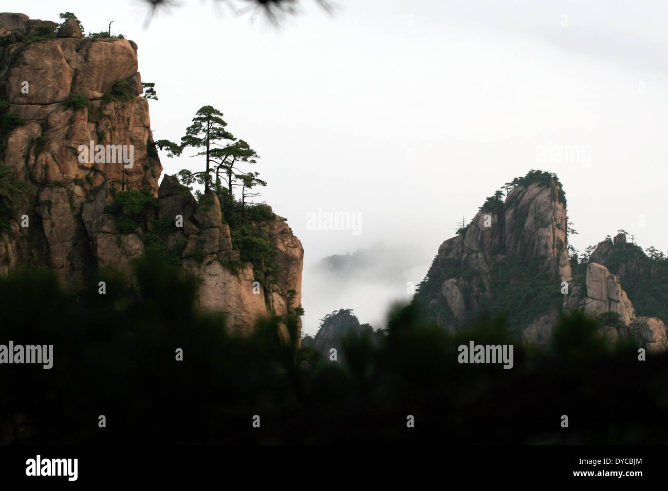 Berggipfel Klippen durch die nebligen Wolken in den Huang Shan-Bergen in China, 19. September 2009. Der Huang Shan-Gebirge gilt als einer der schönsten Bergregionen in China und dient seit Jahrhunderten als eine Motiv-Vorlage für chinesische Malerei. Der Huang Shan-Gebirge wurde ein UNESCO-Weltkulturerbe im Jahr 1990. Foto: Alexandra Schuler - kein Draht-Dienst- Stockfoto