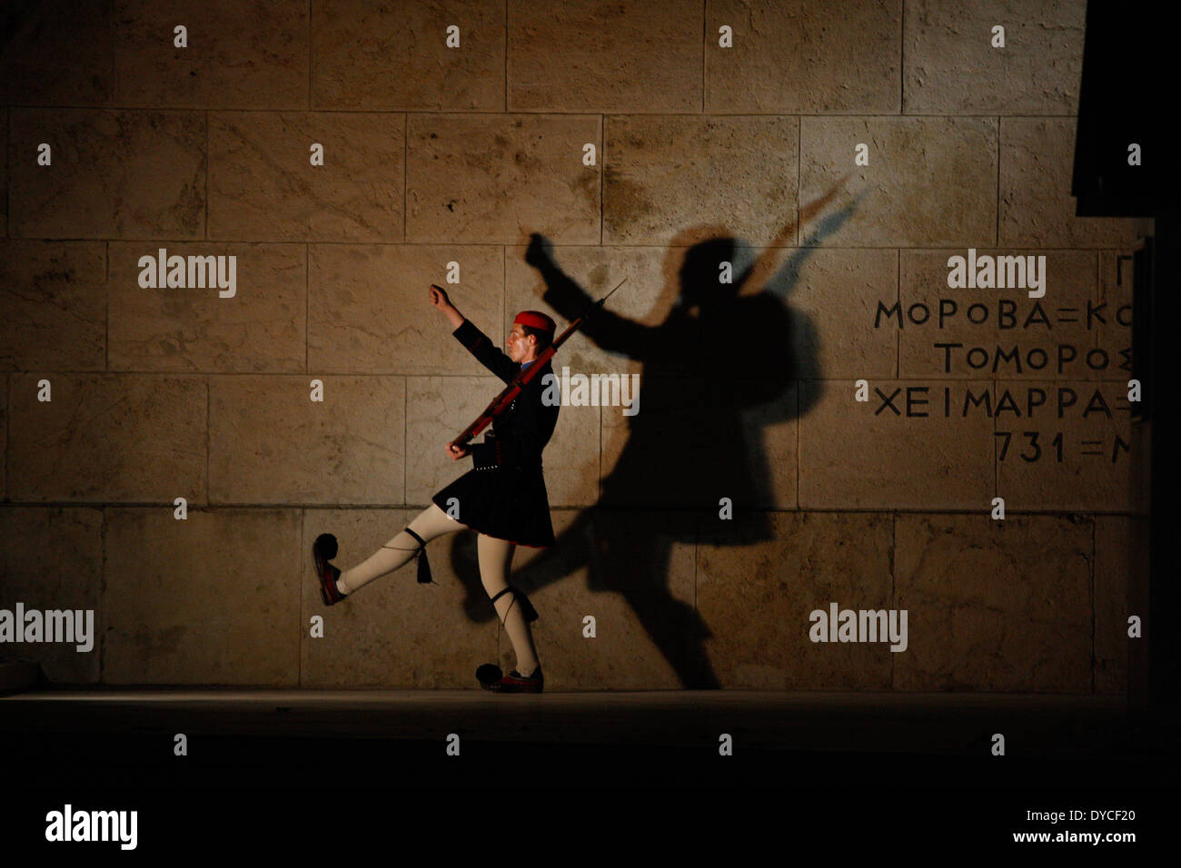 Einen griechischen Präsidenten guard(evzone) wirft seine Schatten am Grab des unbekannten Soldaten vor dem griechischen Parlament, während zeremonielle Aufgaben durchführen. Stockfoto