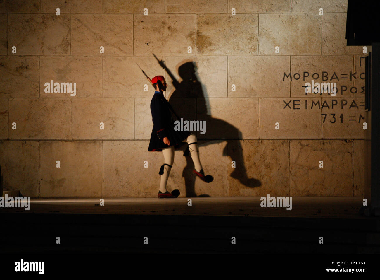 Einen griechischen Präsidenten guard(evzone) wirft seine Schatten am Grab des unbekannten Soldaten vor dem griechischen Parlament, während zeremonielle Aufgaben durchführen. Stockfoto