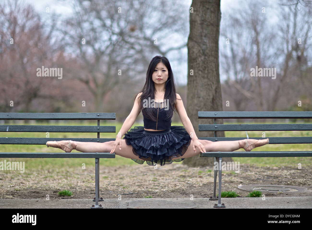 Asiatische Ballerina tragen eine schwarze Tutu balancieren zwischen zwei Parkbänke Stockfoto