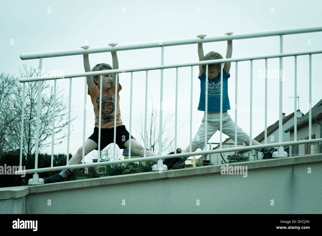Zwei jungen im Freien auf einem Geländer hängen. Stockfoto