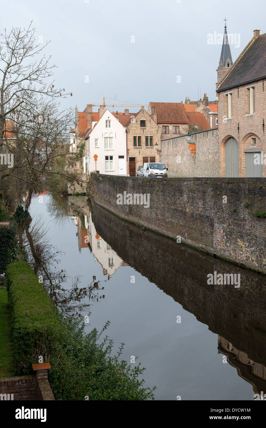 Kanäle im historischen mittelalterlichen Stadtzentrum Brügge Belgien // BRÜGGE, Belgien – Kanäle schlängeln sich durch das mittelalterliche Stadtzentrum von Brügge, Teil eines historischen Wasserstraßensystems, das einst die flämische Stadt zu einem großen Handelshafen machte. Die Kanäle, die durch die Altstadt verlaufen, waren für den Wohlstand Brügge im Mittelalter von entscheidender Bedeutung, als die Stadt ein wichtiger Handelsknotenpunkt in Nordeuropa war. Bevor der Wasserzugang zur Nordsee Ende des 15. Jahrhunderts verschlungen wurde, ermöglichten diese Wasserstraßen den Handelsschiffen, das Stadtzentrum direkt zu erreichen. Heute ist das Kanalsystem ein definierendes Merkmal von B Stockfoto