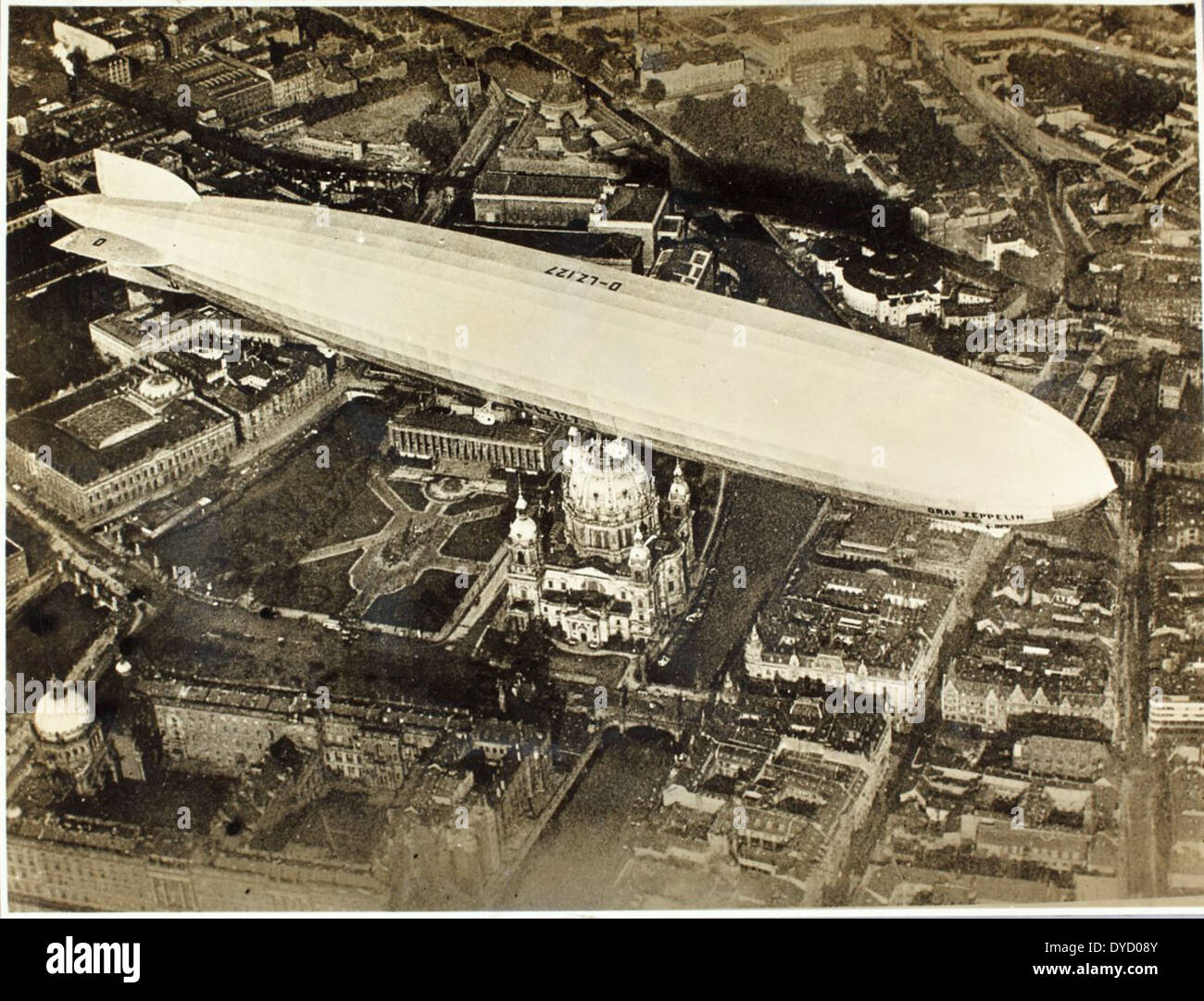 Das AL-47-Bild des Douglas Olsen Albums zeigt den berühmten LZ 127 Graf Zeppelin, ein deutsches Luftschiff, das mehrere bedeutende Reisen absolvierte, darunter das Dole Air Race. Charles Lindbergh, bekannt für seine Leistungen in der Luftfahrt, war mit dem Betrieb des Zeppelins verbunden. Der LZ 127 ist eines der legendärsten dirigiablen Fahrzeuge in der Luftfahrtgeschichte. Stockfoto