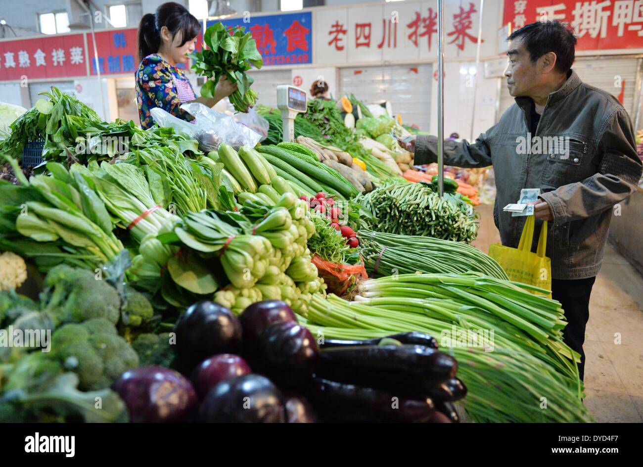 Shijiazhuang, China der Provinz Hebei. 15. April 2014. Ein Bewohner kauft Gemüse auf einem Markt in Shijiazhuang, Hauptstadt der Provinz Hebei North China, 15. April 2014. Chinas Gemüsepreise sind innerhalb der letzten 6 Wochen durch ausreichende Versorgung, nach Angaben von Ministry of Commerce veröffentlicht am 15. April um 9,7 Prozent gesunken. © Zhu Xudong/Xinhua/Alamy Live-Nachrichten Stockfoto