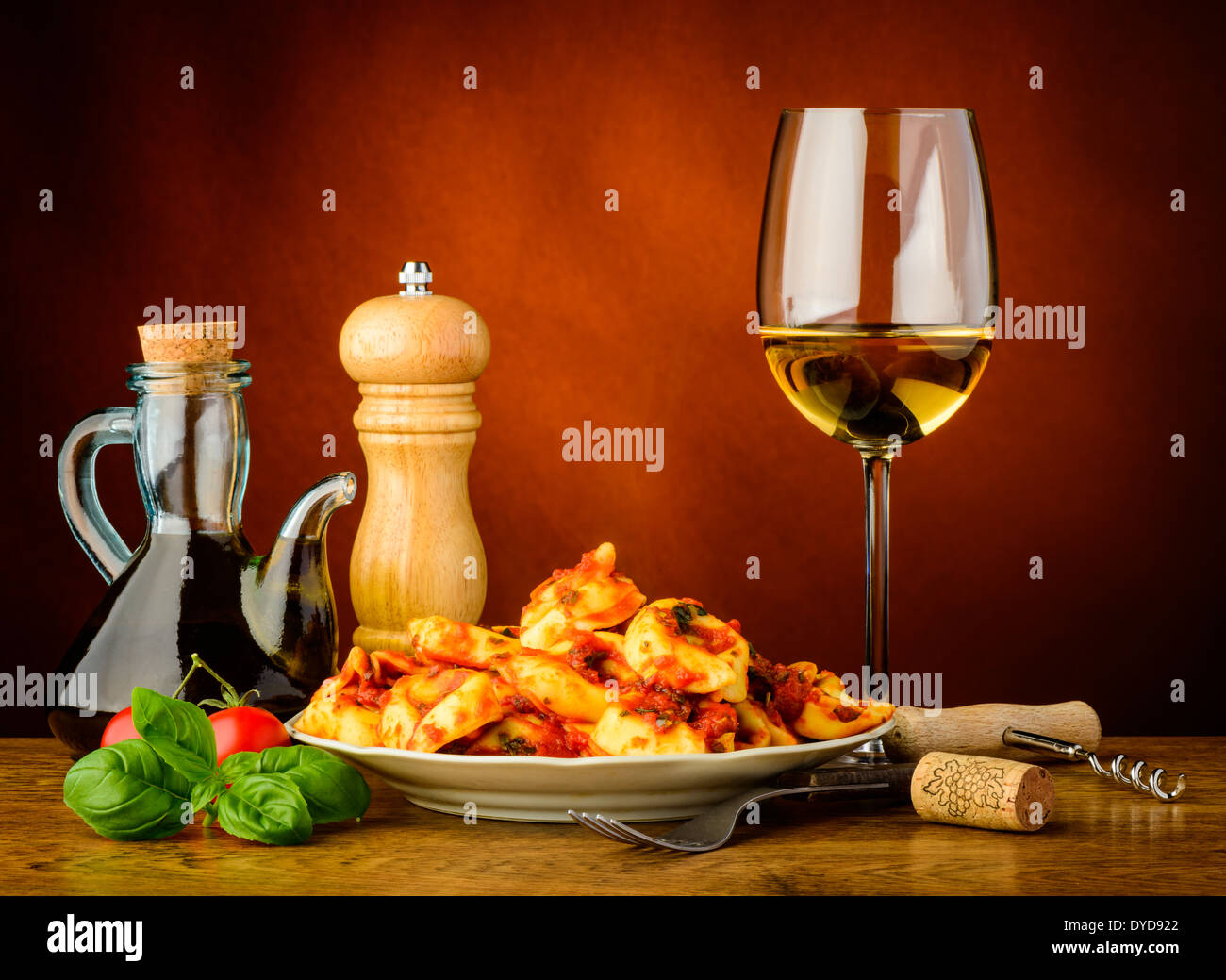 Stillleben mit traditionellen Tortellini Nudeln Essen und ein Glas Weißwein Stockfoto