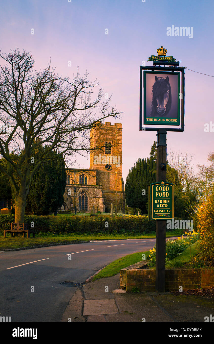 Der Black Horse Pub Schild und Dorf Kirche von Foxton. Stockfoto