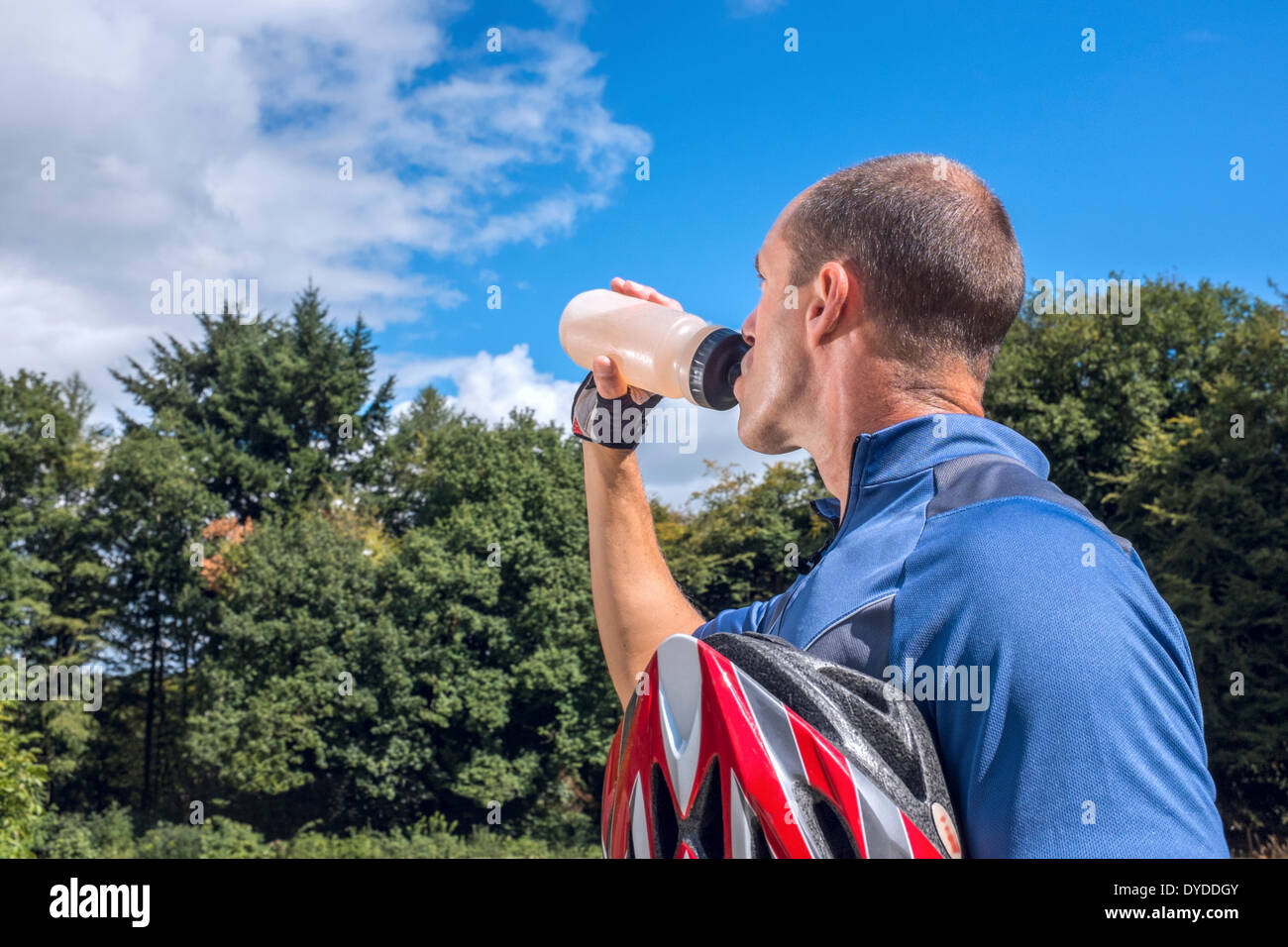 Männliche Radfahrer trinken aus einer Flasche Wasser. Stockfoto