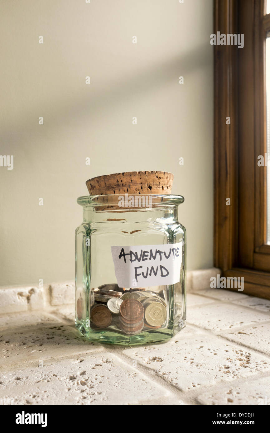Glas gekennzeichnet Abenteuer Fonds mit Kleingeld. Stockfoto