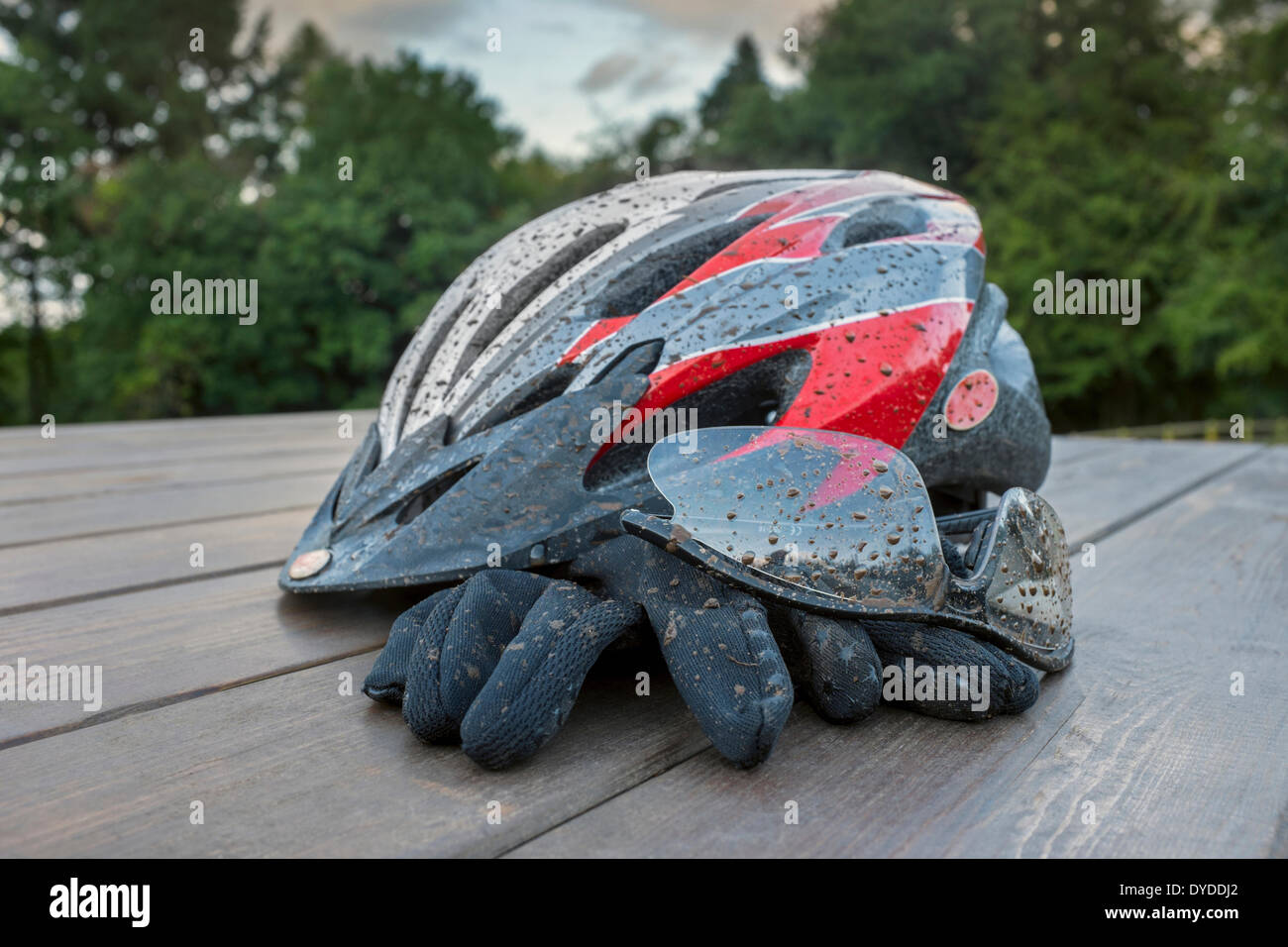 Schlamm bespritzt Fahrradhelm mit Brille und Handschuhe. Stockfoto