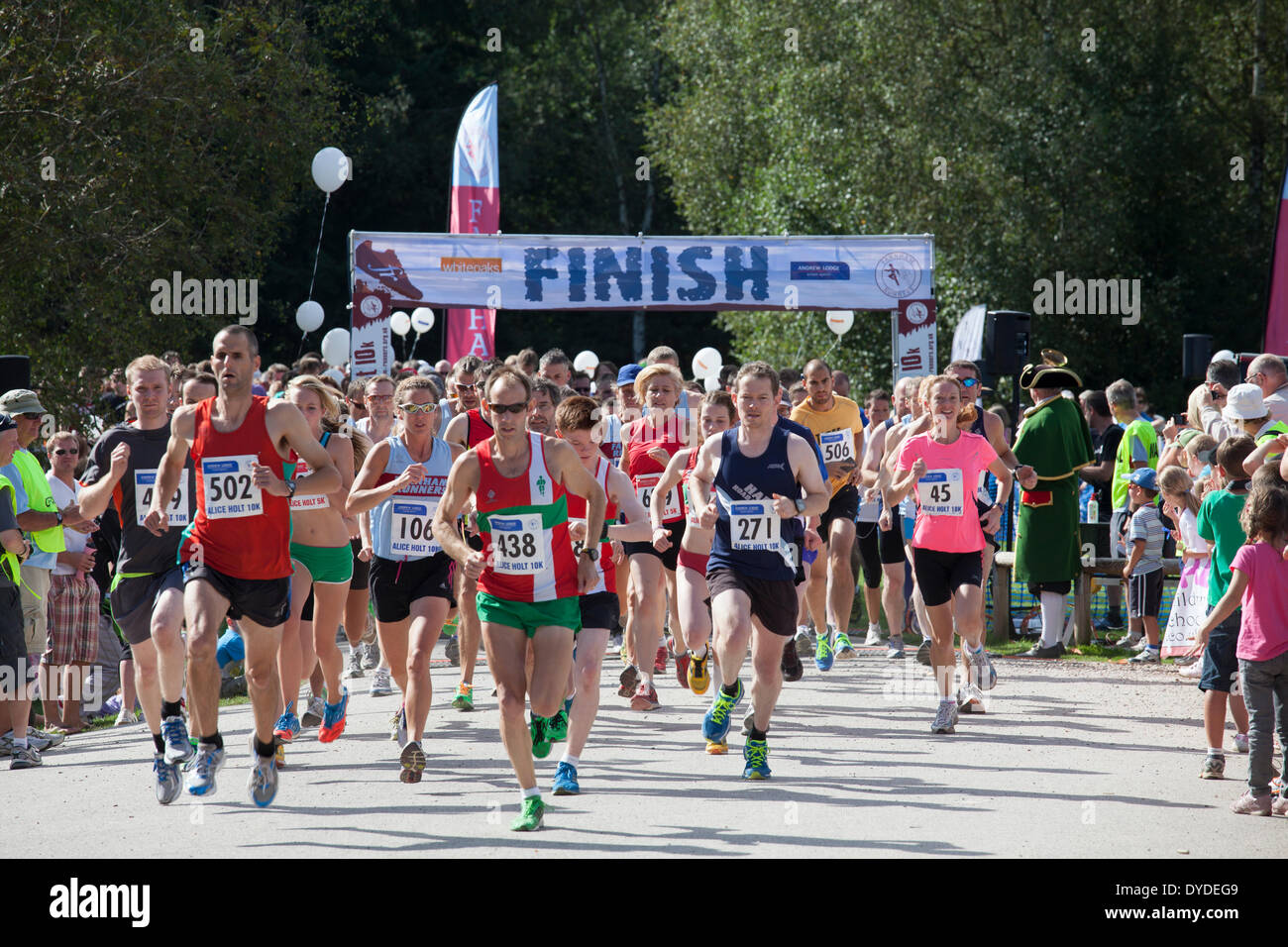 Läufer ab 10k und 5 k laufen bei Alice Holt Wald mit Finish-Zeichen. Stockfoto