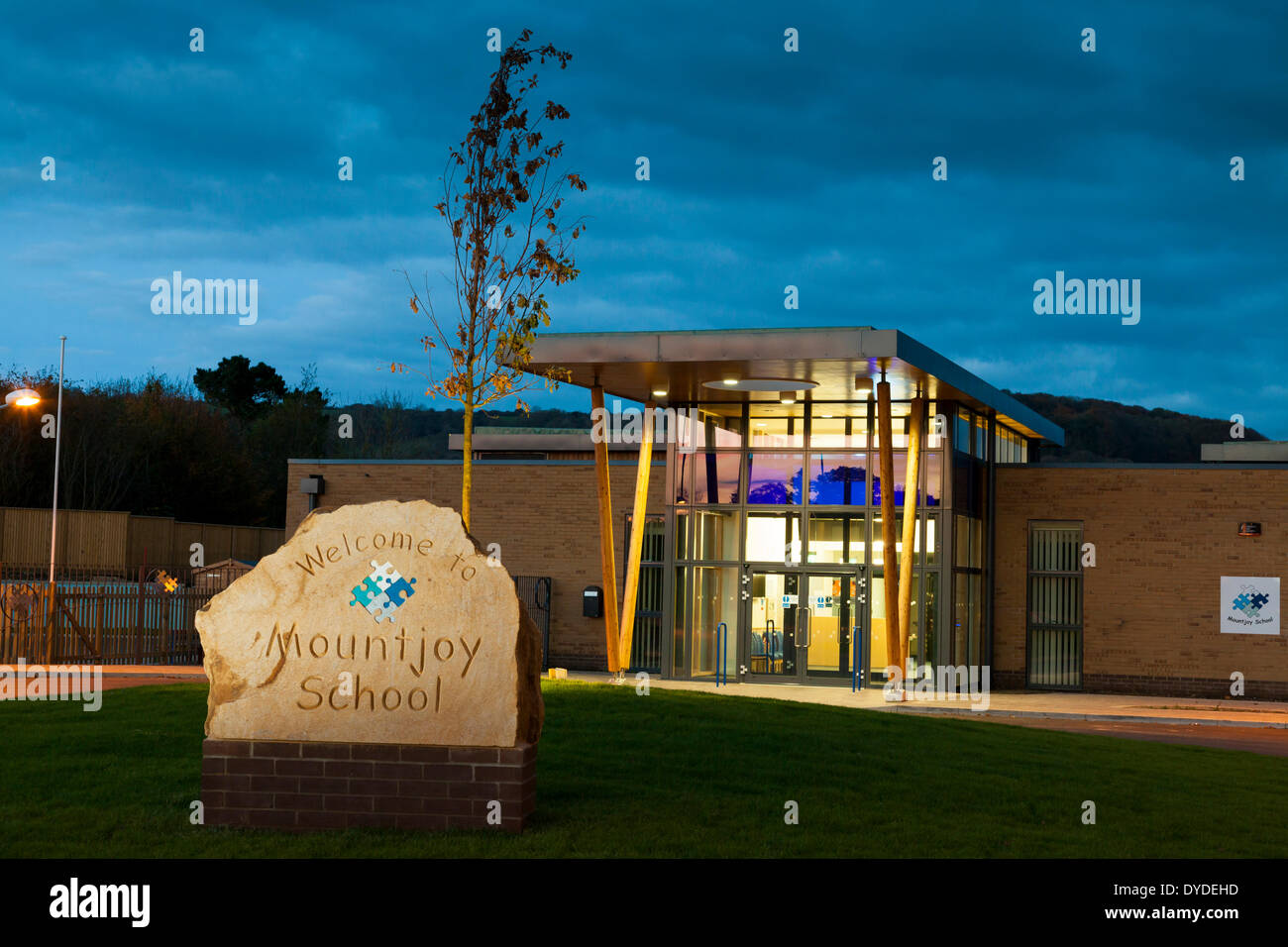 Name der Schule auf Stein am Haupteingang zur Mountjoy-Schule in Beaminister in der Abenddämmerung geschnitzt. Stockfoto