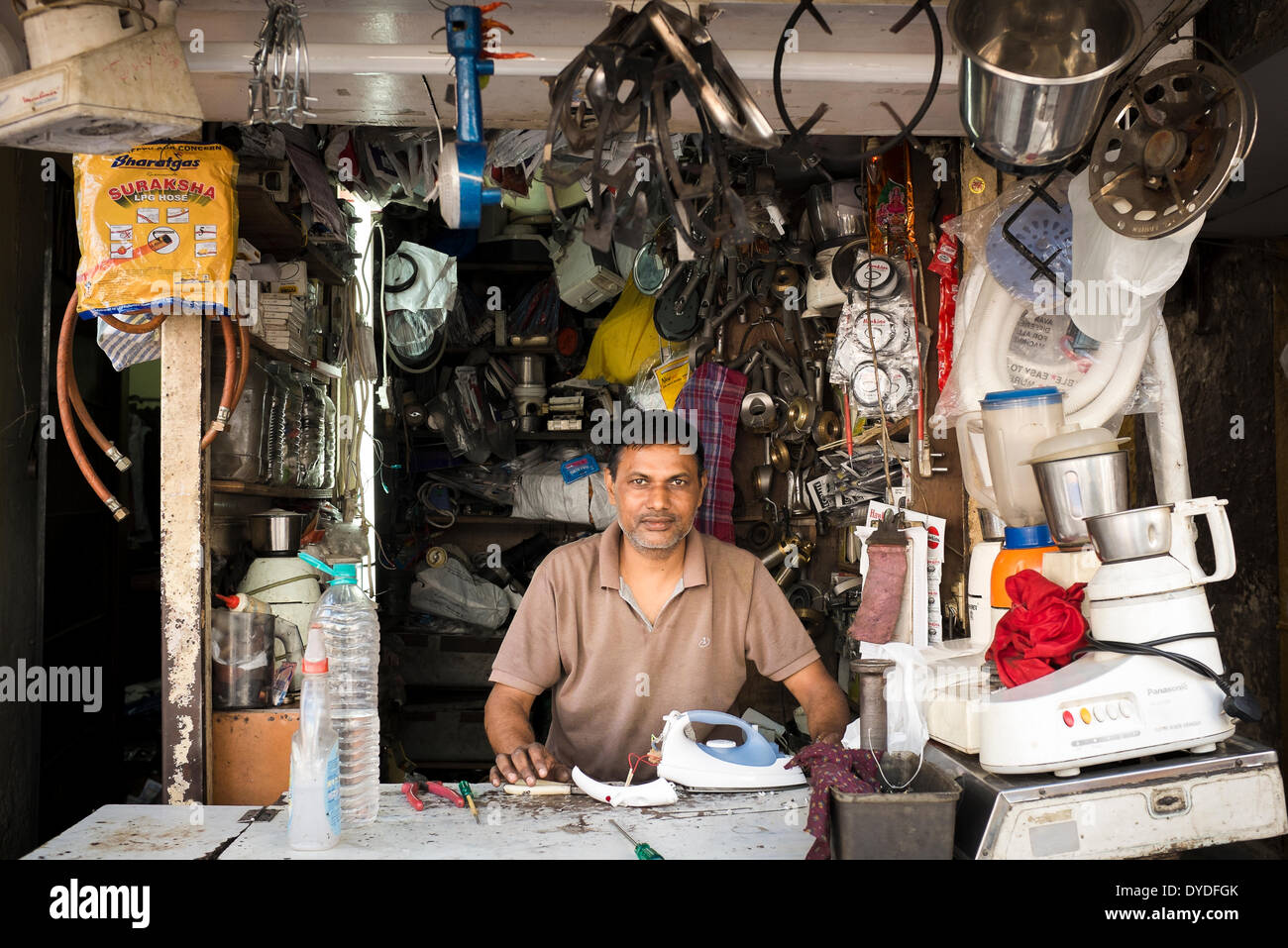 Ein Mann hinter der Theke seiner Werkstatt, spezialisiert auf Reparaturen von Gas- und elektrische Küchengeräte. Stockfoto