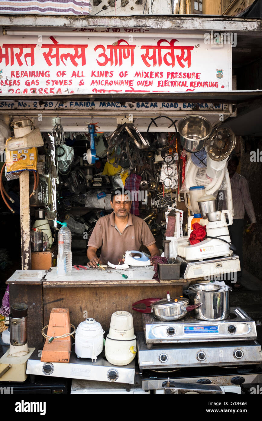 Ein Mann hinter der Theke seiner Werkstatt, spezialisiert auf Reparaturen von Gas- und elektrische Küchengeräte. Stockfoto
