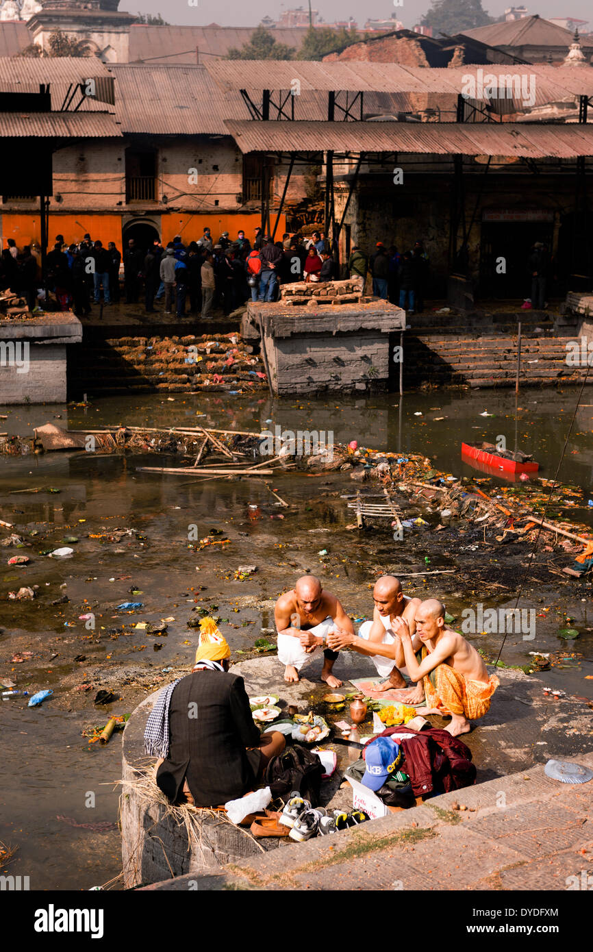 Mönche beten in den Banken des Flusses Bagmati im Pashupatinath Tempel in Kathmandu. Stockfoto