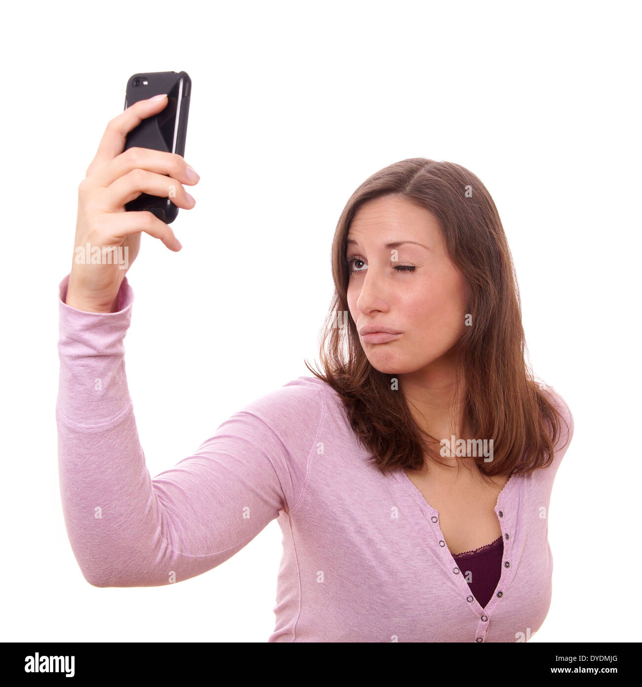 junge Frau macht eine dumme Gesicht während der Einnahme ein Selbstporträt mit ihrem Smartphone Stockfoto