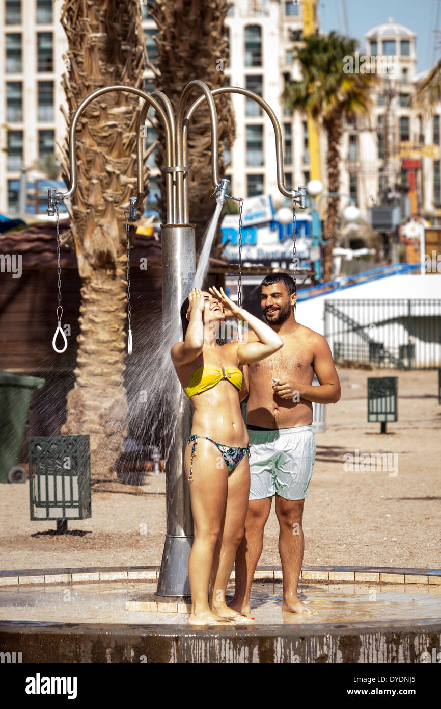 Paar unter der Dusche am Strand, Eilat, Israel. Stockfoto