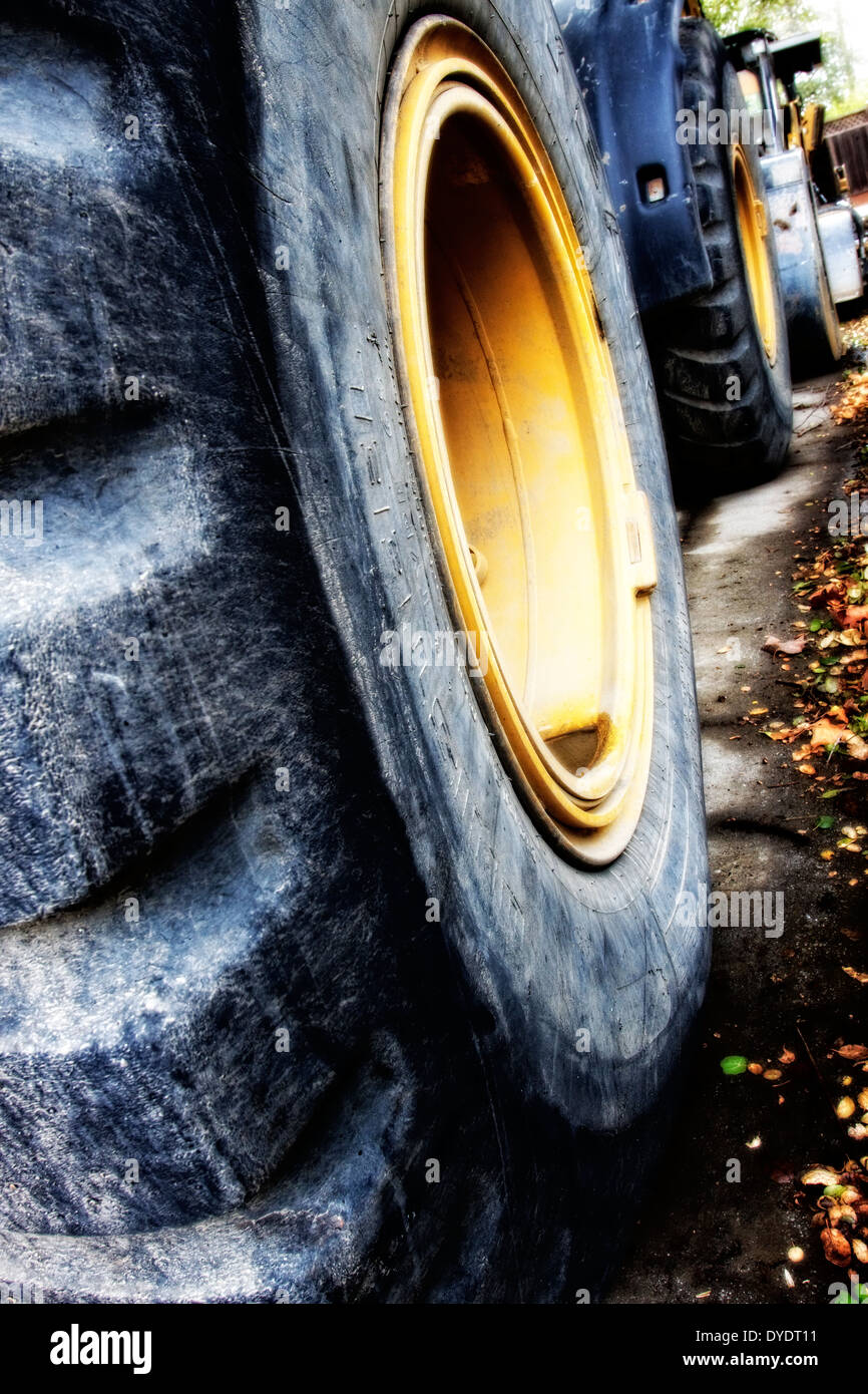 Die stilisierte Abbildung des riesigen Planierraupe Reifen aufgereiht entlang einer Straße bei Bauvorhaben Stockfoto
