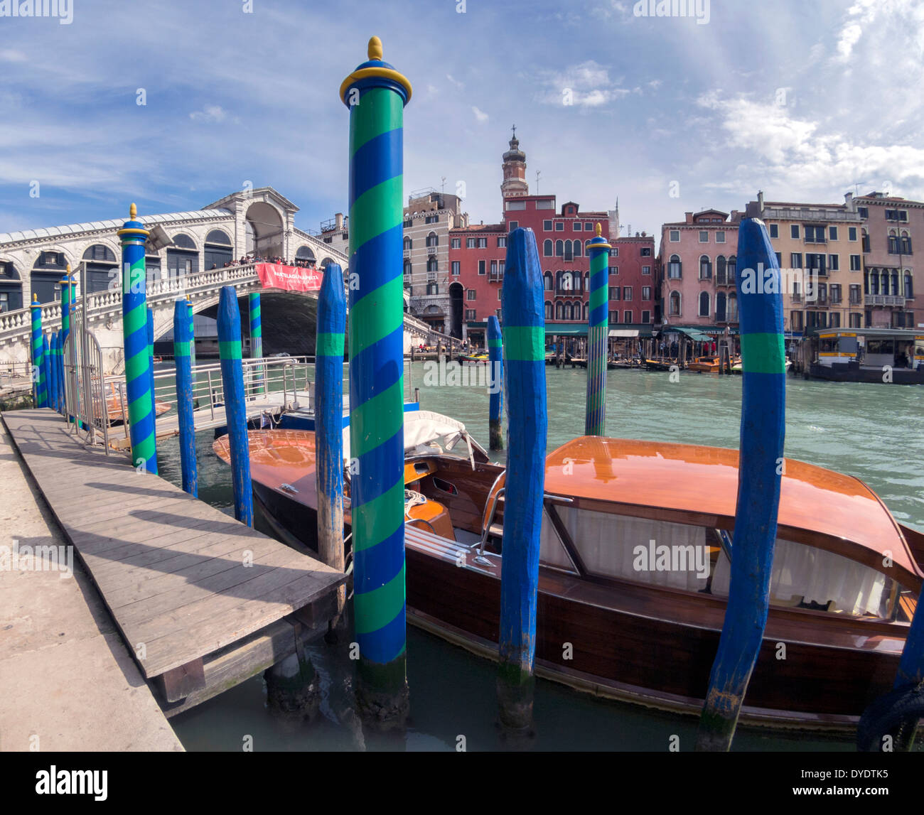 Rialto-Brücke über den großen, Venedig, Italien, mit einem Wassertaxi und gestreiften Liegeplätze: Weitwinkel fotografiert von Riva del Vin Stockfoto