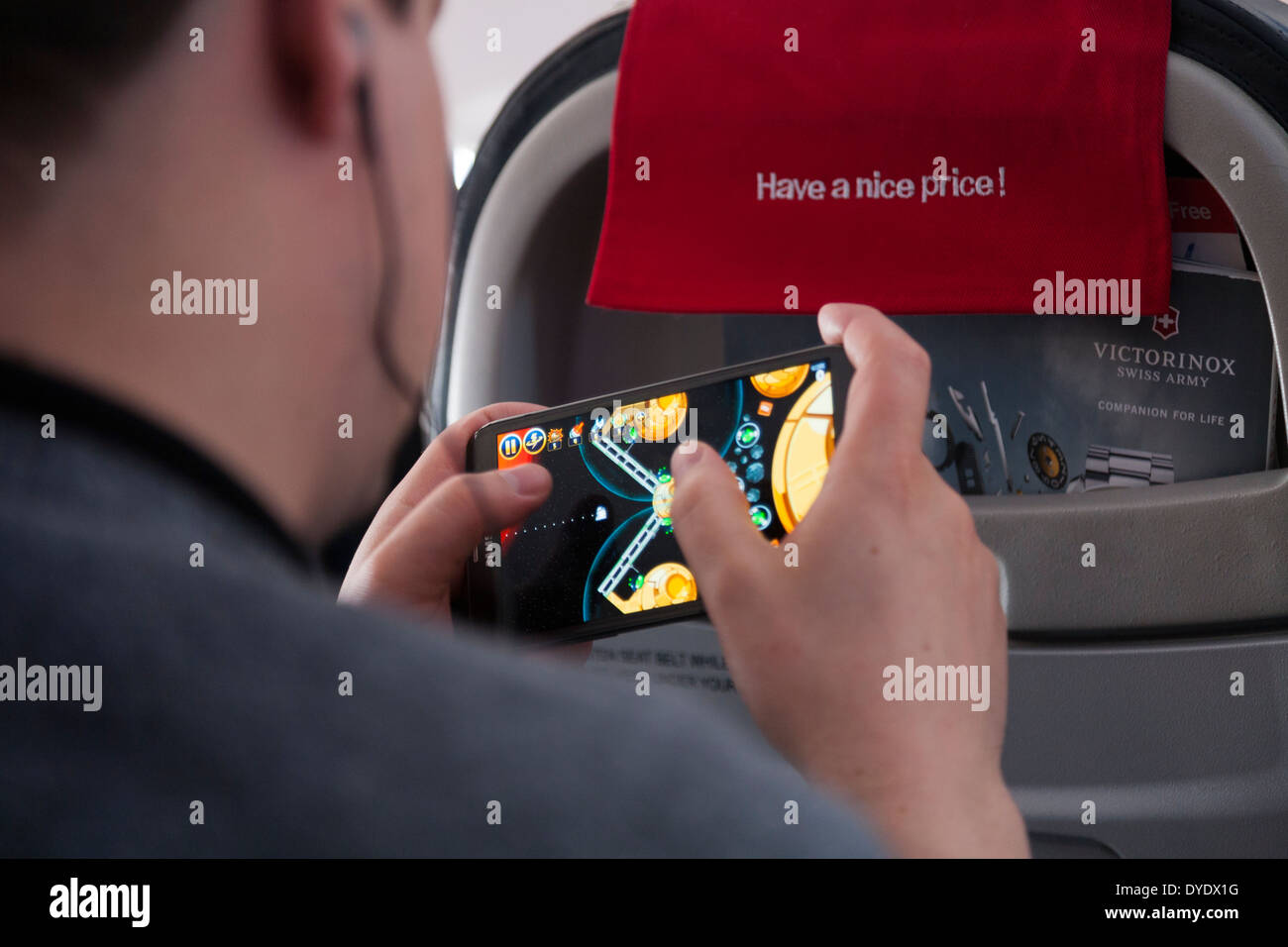 Männlichen Passagier ein Videospiel spielen, auf seinem Samsung Tablet-Computer / mobile Phone - im Flugmodus, auf einem Norwegian.com Flug Stockfoto