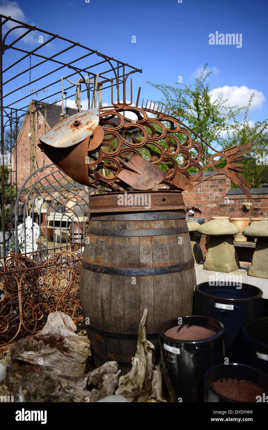 Ein Fisch Skulptur mit zurückgefordert Elemente wie z. B. Hufeisen, Schraubenschlüssel und Garten Gabelzinken. Fotografiert in einem Garten laden. Stockfoto