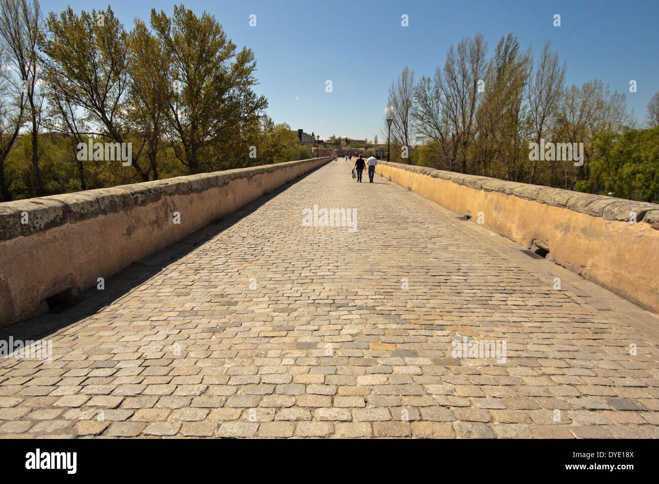 Menschen flanieren an der Puente Romano auch bekannt als die alte römische Brücke, Salamanca, Castilla y León, Spanien. Stockfoto