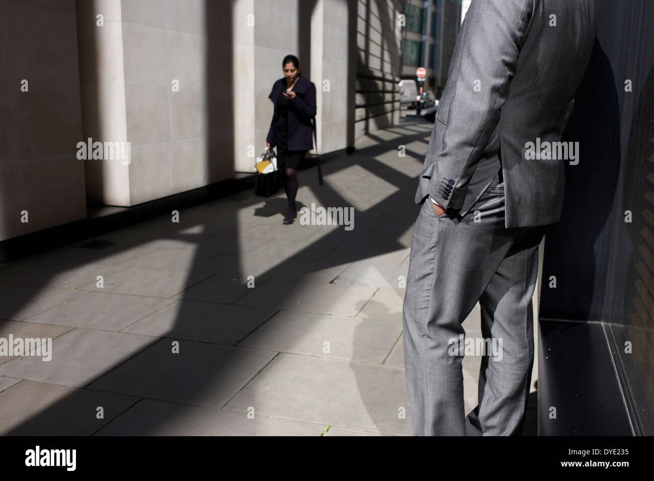 Anonyme Mann glänzend grauen Anzug steht in sonnigen Gasse in der City of London. Stockfoto