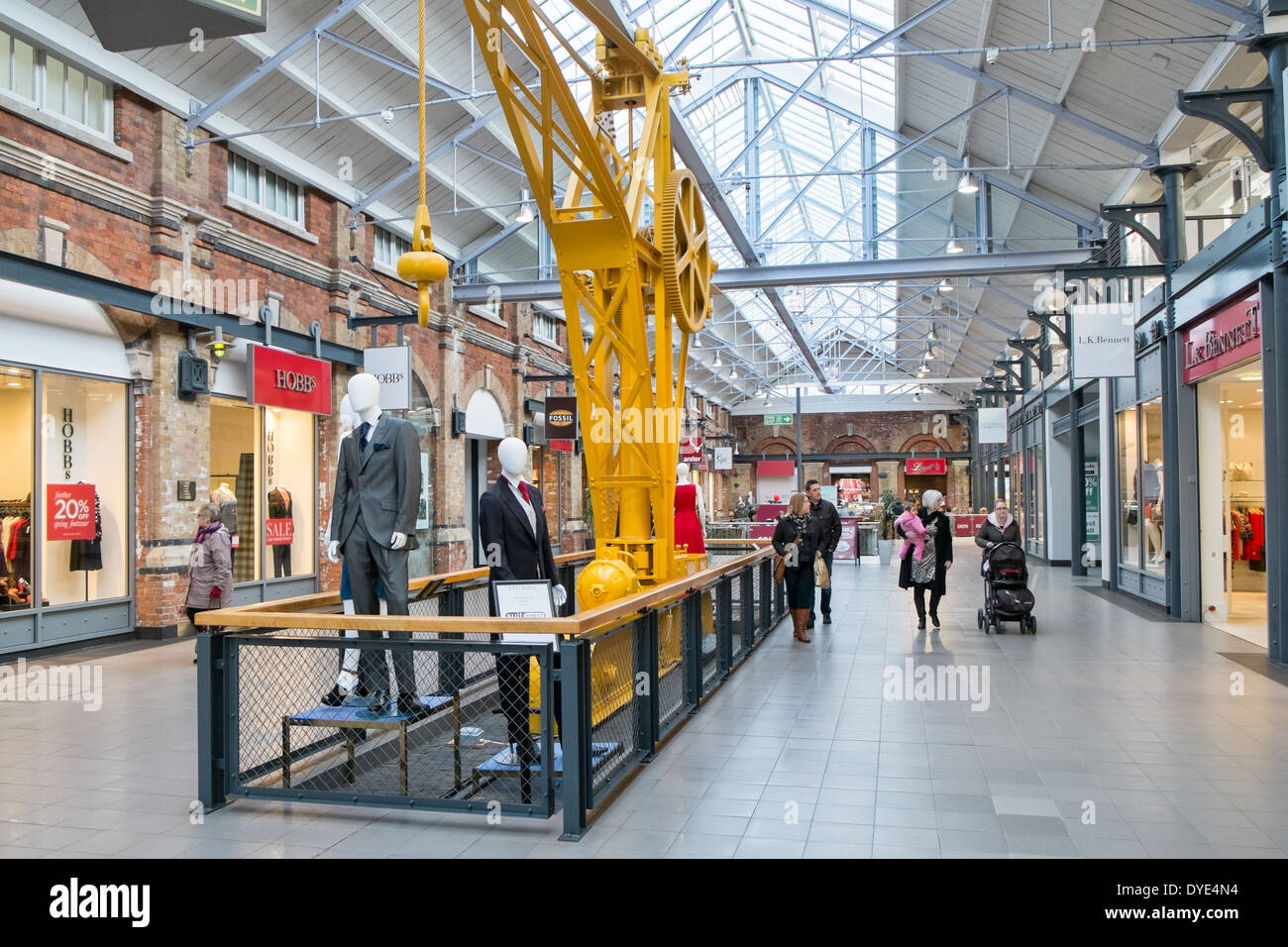 Shopper, Geschäfte & alte Maschinen an die konvertierten Schiene funktioniert, jetzt McArthur Glenn Designer-Outlet-Village in Swindon, Wiltshire Stockfoto