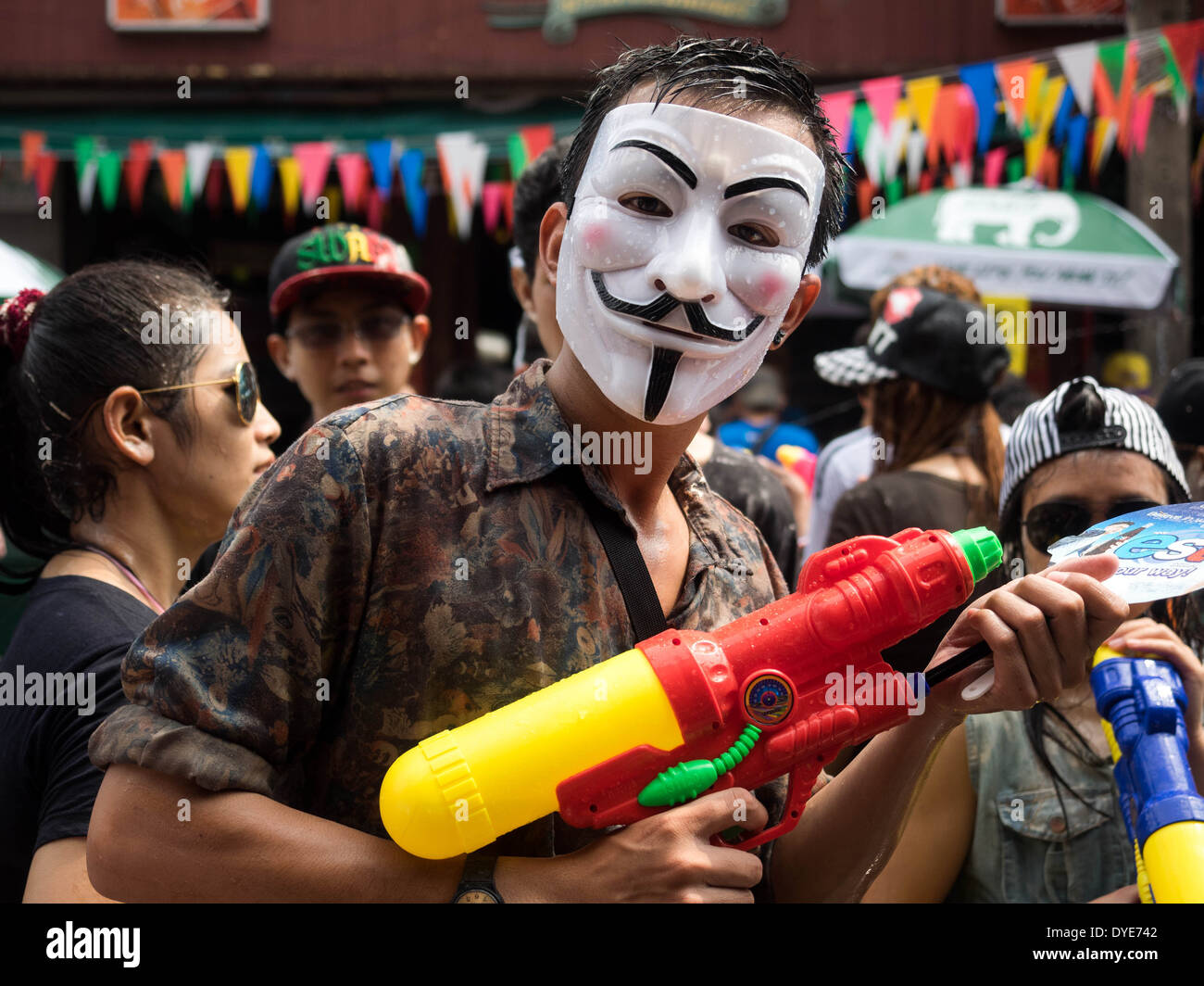 Maskierte Mann hält Wasser Gewehr auf der Khao San Road feiert das traditionelle thailändische Neujahr (Songkran) in Bangkok, Thailand. Stockfoto