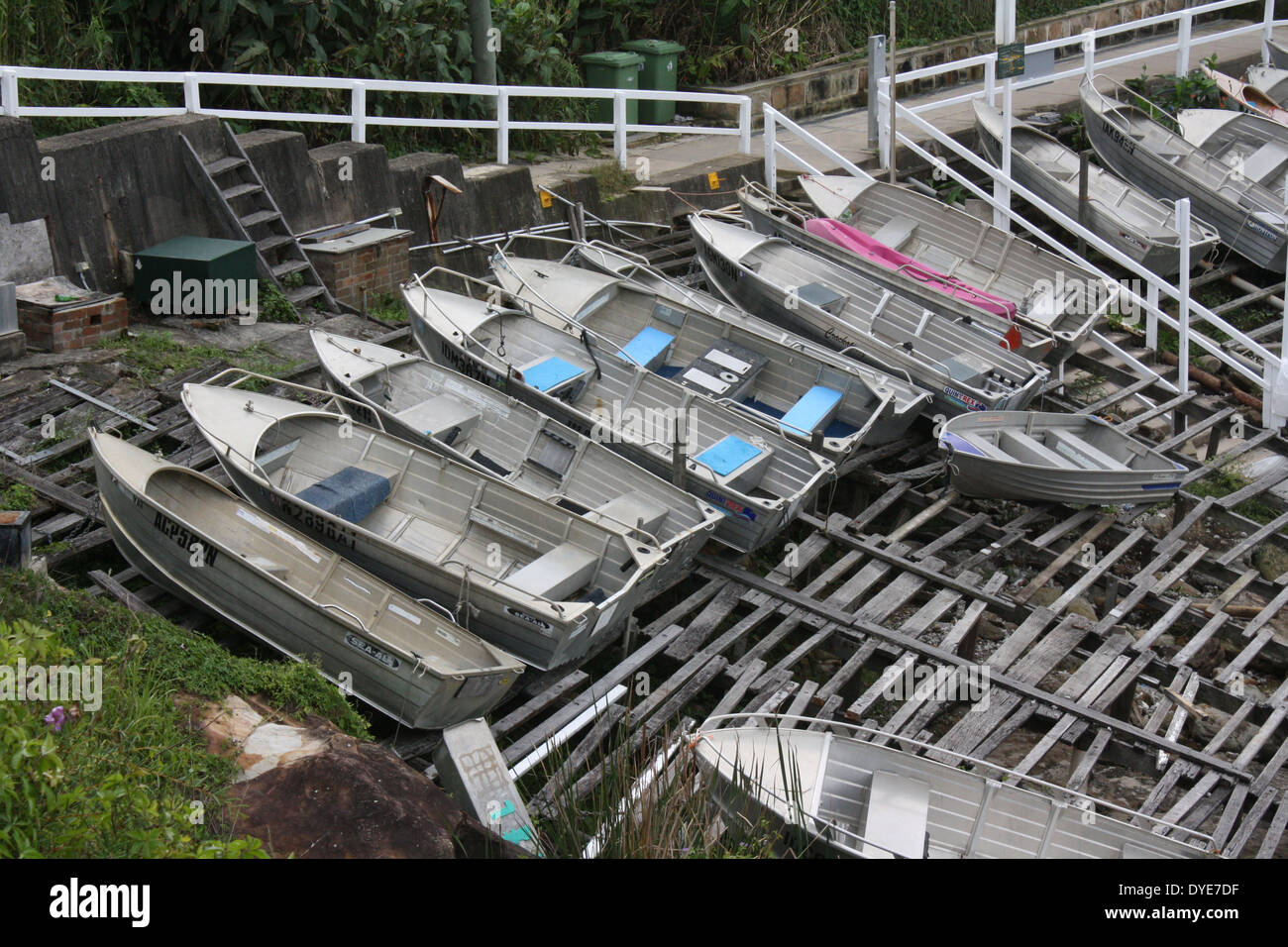 Eine Gruppe von kleinen Booten, die über der Flut-Linie im Gordons Bay Fishing Club in der Nähe von Coogee, Australien, gezogen wurden. Das Hotel liegt am Coogee zu Bondi Küstenweg. Stockfoto