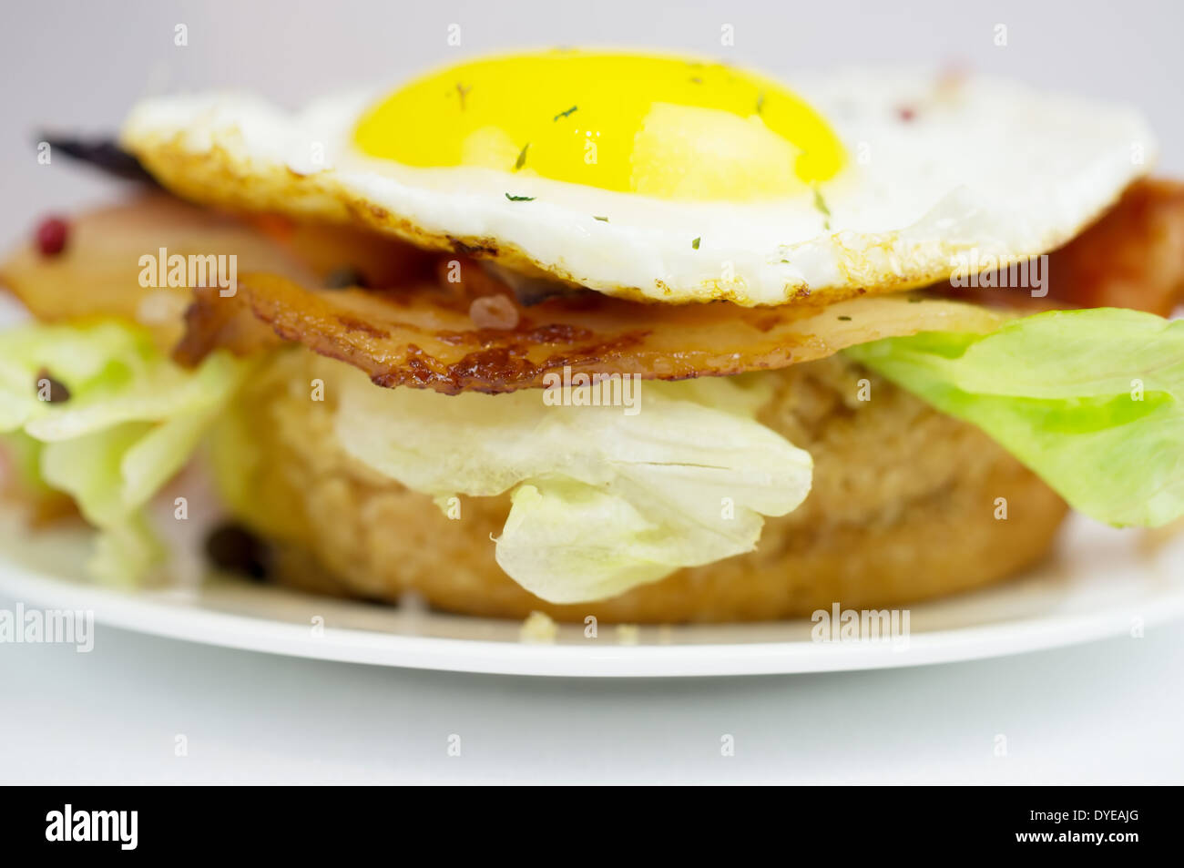 Burger mit Spiegeleiern und Speck-Salat Stockfoto