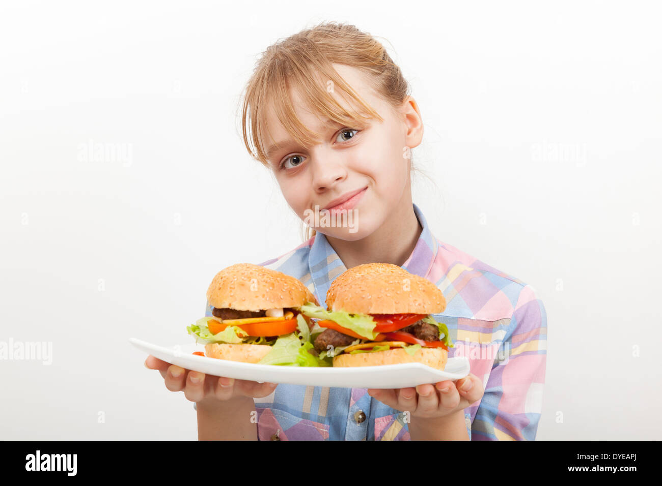 Lächelnden blonden Mädchen mit hausgemachten Hamburgern auf weißen Teller Stockfoto