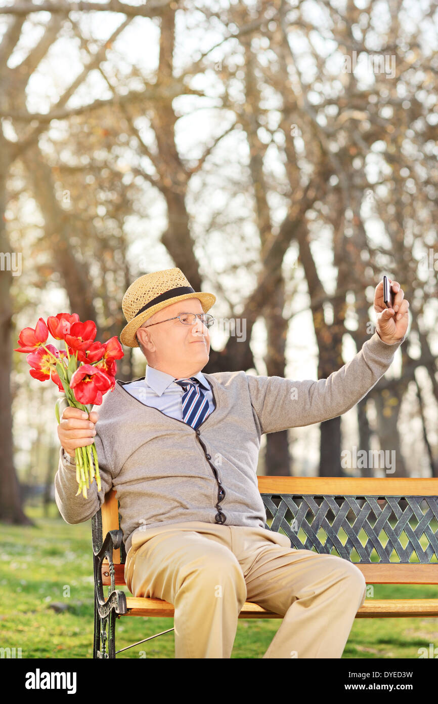 Ältere Menschen halten Tulpen und nehmen Selfie im freien Stockfoto