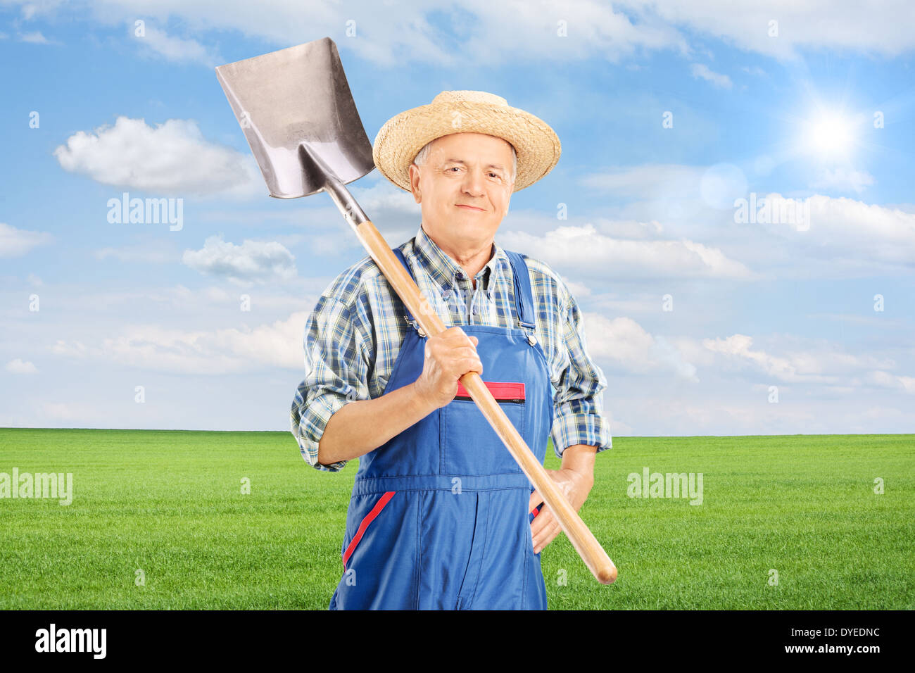 Reife Landarbeiter halten Schaufel im Feld Stockfoto