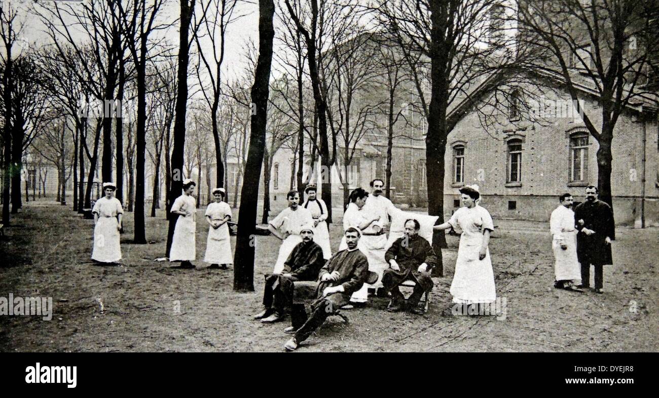 Paris 1900. Patienten und Pflegepersonal auf dem Gelände des Krankenhaus de Lariboisiere. Das Krankenhaus war einer von mehreren gebaut nach dem Zweiten Cholera Epidemie, die Paris 1832 erreicht hatte, und das führte zu einem neuen Schwerpunkt auf Hygiene in Krankenhäusern. Es war von 1846 bis 1853 Unter Architekt Pierre Gauthier gebaut, mit sechs Gebäuden, die um einen zentralen Innenhof angeordnet, durch die Kolonnaden Gehwege verbunden. Stockfoto