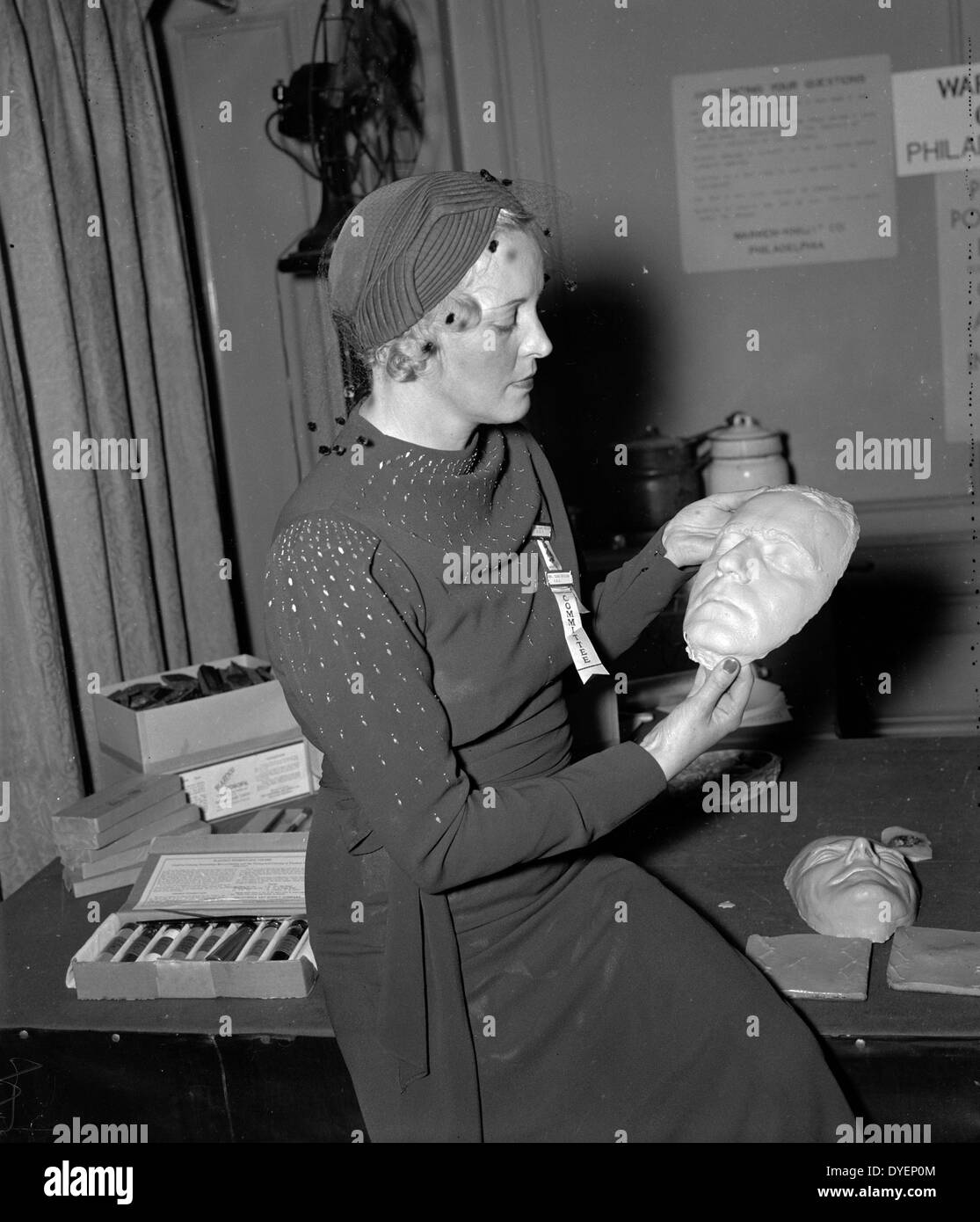 Totenmasken bei der Identifizierung. Sept. 29. Frau Clark Schilder, die Frau von der Leiter der Abteilung der Identifikation, FBI, prüft eine Totenmaske der Gefangenen Kriminellen auf der Jahrestagung der International Association Identifikation, der hier heute eröffnet. Totenmasken der Verbrecher sind nun in der Regel von der Polizei Büros im ganzen Land zu Identifikationszwecken verwendet. Datum 19370101 Stockfoto