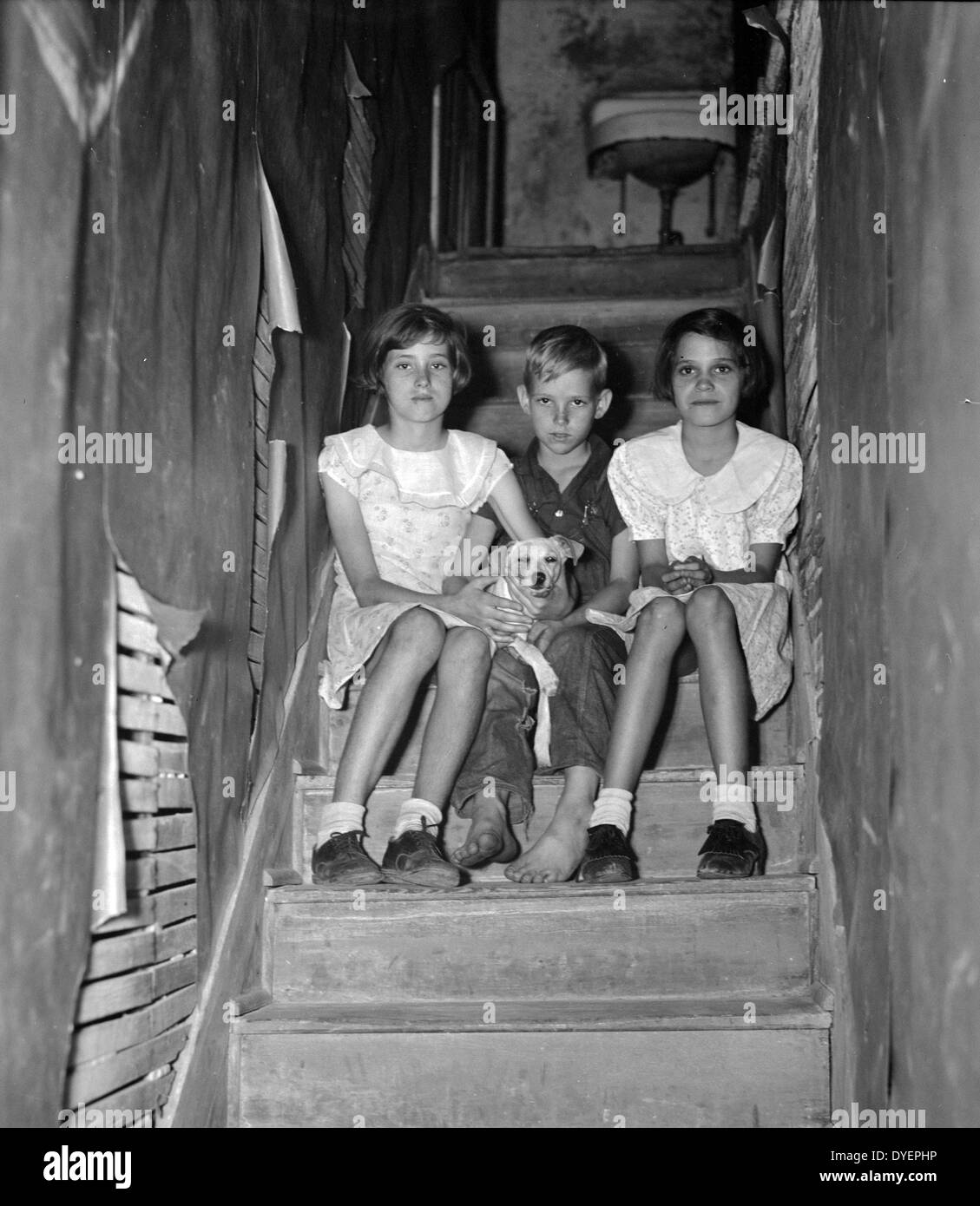 Kinder von Wanderarbeitnehmern citrus Arbeiter, der in einem heruntergekommenen Apartment lebt. Das Waschbecken an der Spitze der Treppe ist die einzige fließendes Wasser im Haus. Winterhaven, Florida 19370101 Stockfoto