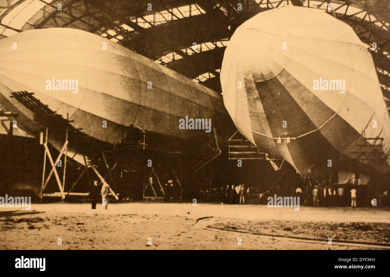 Ein Foto von zwei Zeppeline in einem Hangar. Als "deutschen Dreadnoughts der Luft' ein Zeppelin ist eine Art von starren Luftschiff ursprünglich aus den Konzepten von Ferdinand Graf von Zeppelin im frühen 20. Jahrhundert angelegt. Erste kommerziell 1910 geflogen, und weitgehend als Bomber im Ersten Weltkrieg durch die Deutschen. Erfahrene Popularität als Methode der Flug in den 1930er Jahren, aber die 1937 Hindenburg disaster, sowie politische/wirtschaftliche Fragen, begann der Rückgang in der Nutzung der Zeppeline. Stockfoto