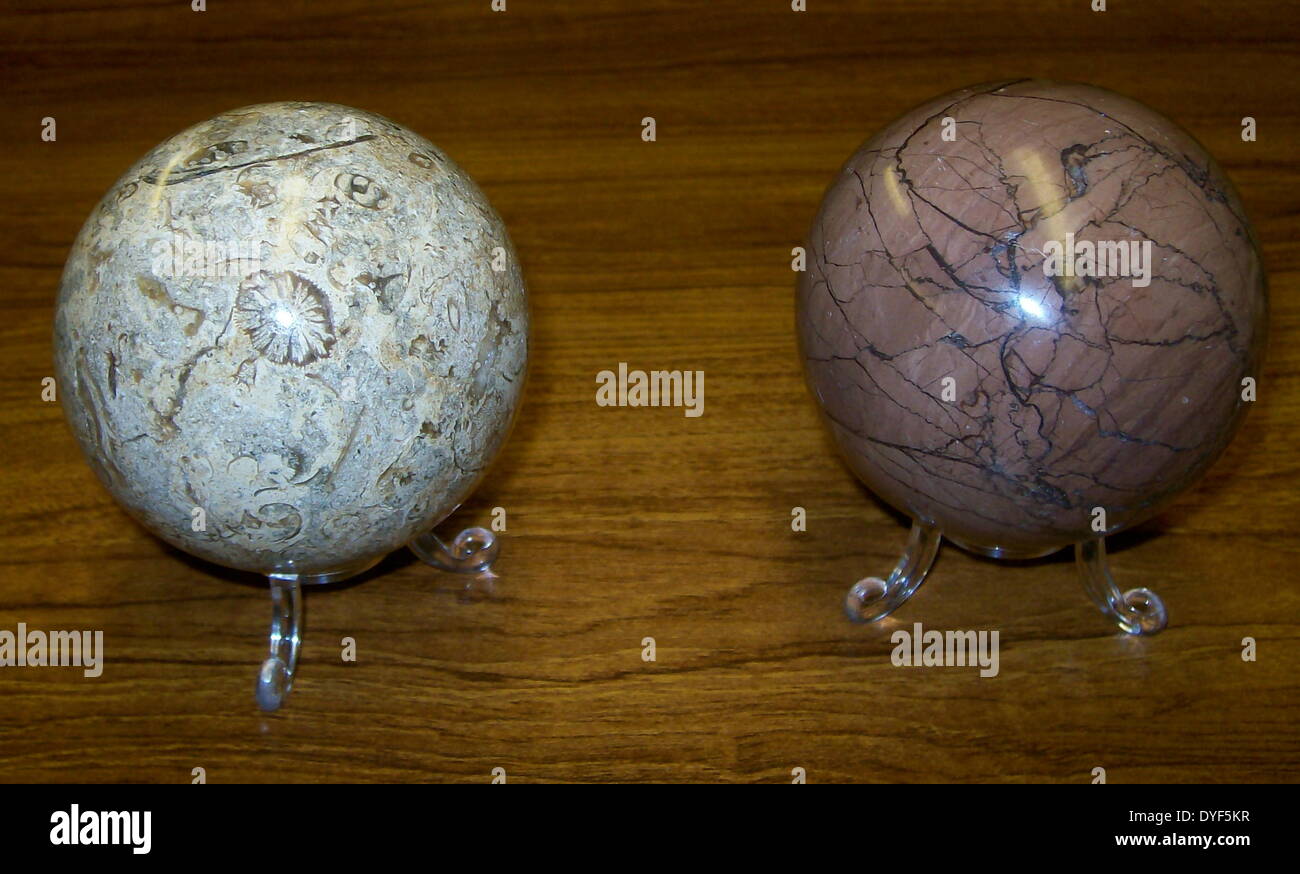 Links: fossile Korallen Kugeln; rechts: steinerne Kugel. Stockfoto