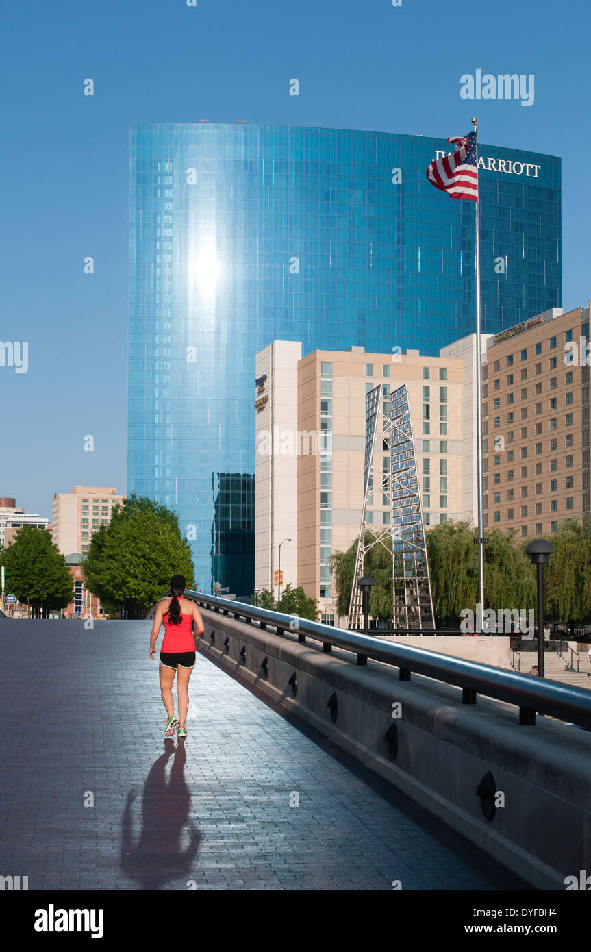 USA, Indiana, Indianapolis. Frau joggen durch den White River State Park in Richtung das JW Marriott Hotel Stockfoto