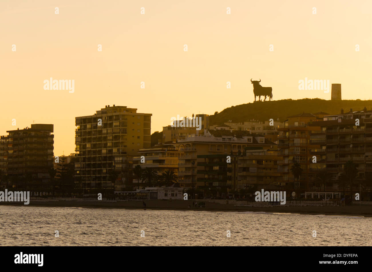 Sonnenuntergang an der Küste von Fuengirola mit Osborne Stier, der einem spanischen Wahrzeichen geworden ist. Costa Del Sol, Spanien. Stockfoto